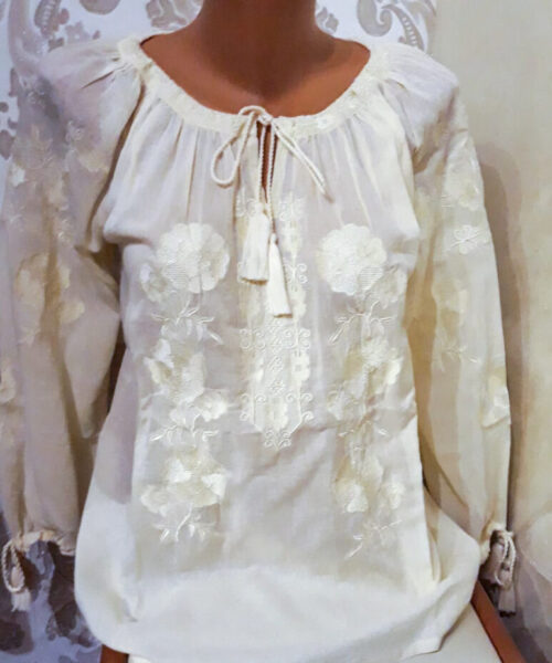 Ie traditionala de damă, de culoare crem cu model floral auriu.